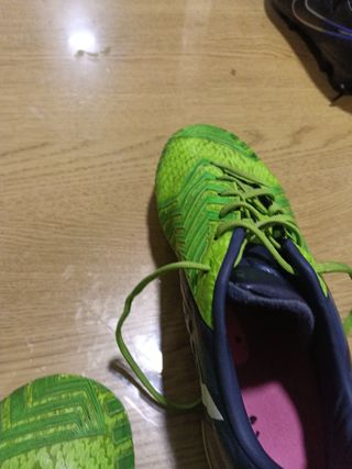 Botas de fútbol Adidas verdes con azul.