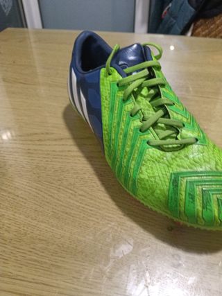 Botas de fútbol Adidas verdes con azul.