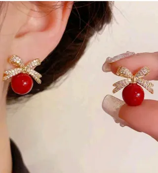Pendientes dorados con lazo y perla roja