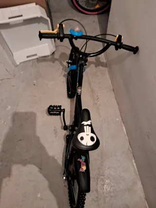 Bicicleta infantil negra con timbre azul