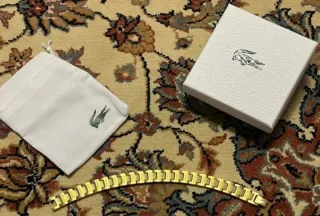 Pulsera Lacoste dorada con caja