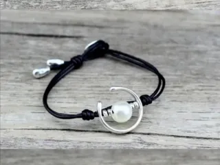 Pulsera símil piel con perla y detalles plateados