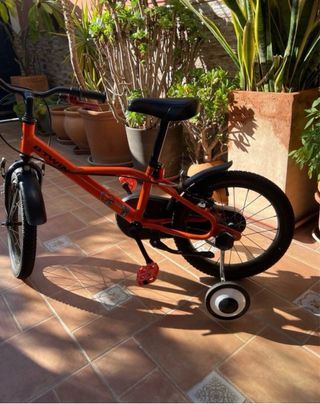 Bicicleta infantil naranja niño con ruedines