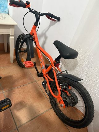 Bicicleta infantil naranja niño con ruedines