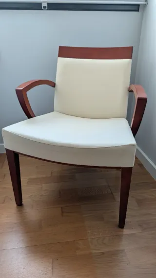 Butaca tapizada color crema y madera.