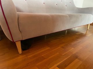 Sofá de tela gris con detalles rojas