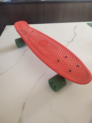 Monopatín rojo con ruedas verdes