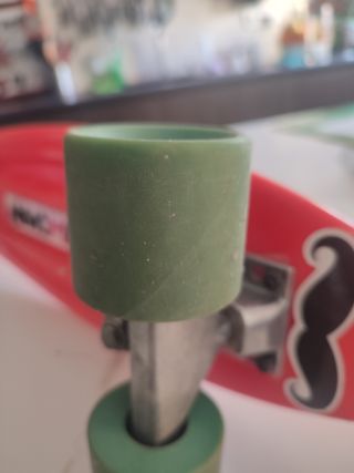 Monopatín rojo con ruedas verdes