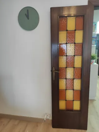 Puertas dobles de madera y cristales emplomados.