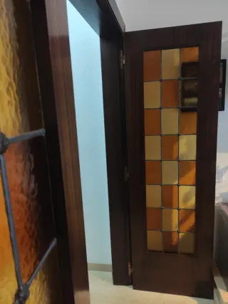 Puertas dobles de madera y cristales emplomados.