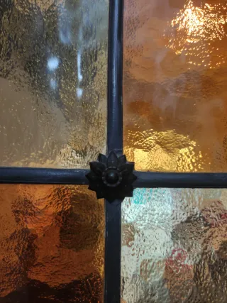 Puertas dobles de madera y cristales emplomados.