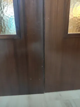 Puertas dobles de madera y cristales emplomados.