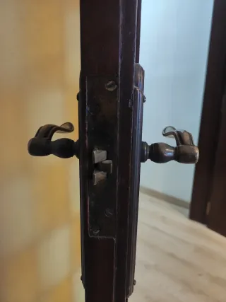 Puertas dobles de madera y cristales emplomados.