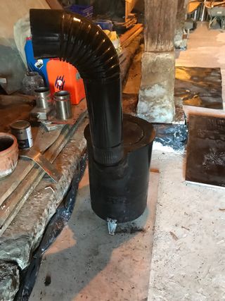 Estufa de leña negra con tubo