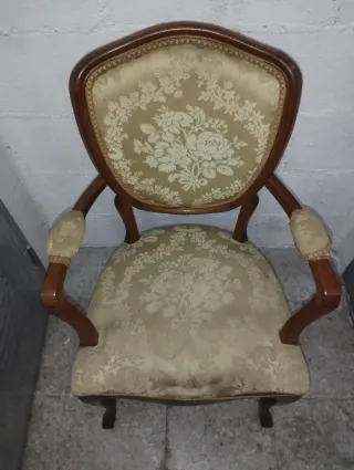 Antigua butaca de madera tapizada estilo clásico