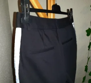 Pantalón negro con tira lateral blanca y bolsillos