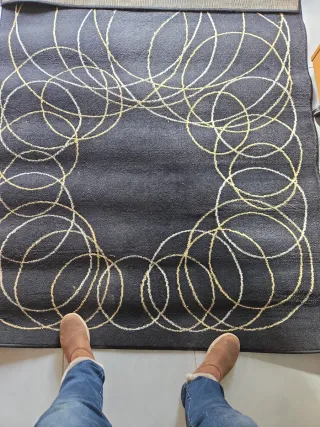 Alfombra negra con diseño de círculos dorados