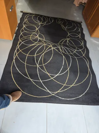 Alfombra negra con diseño de círculos dorados
