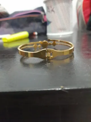 Pulsera de acero dorada con diseño floral