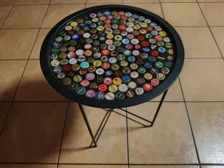 Mesita redonda con 180 chapas de cerveza