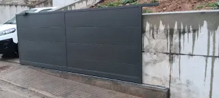 Fabricación de Puerta corredera con peatonal gris