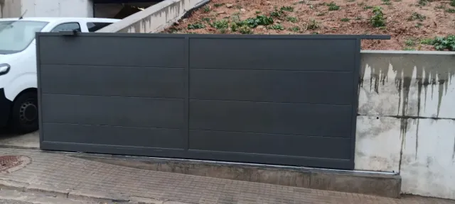 Fabricación de Puerta corredera con peatonal gris