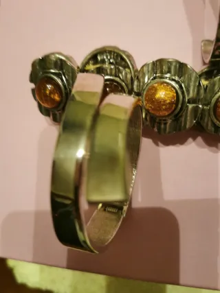 Pulseras plateadas, una con piedras de. Ambar