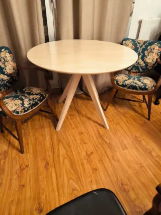 Mesa redonda de madera color beige.