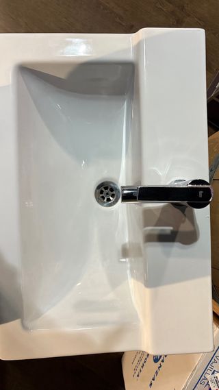 Mueble de baño blanco con lavabo y grifo