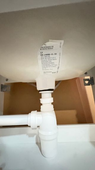 Mueble de baño blanco con lavabo y grifo