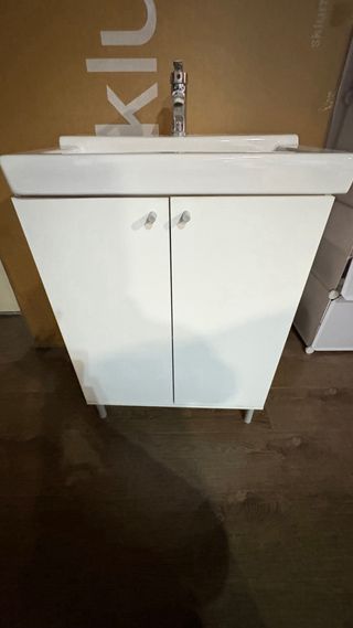 Mueble de baño blanco con lavabo y grifo