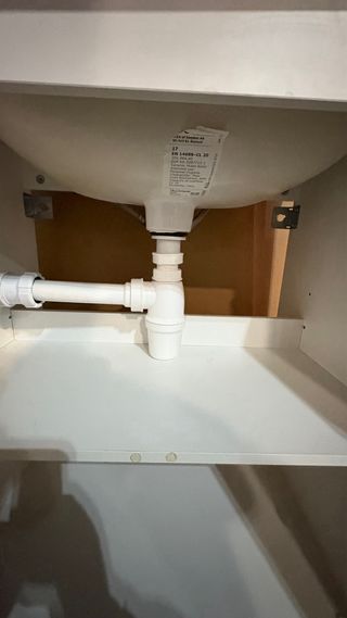 Mueble de baño blanco con lavabo y grifo