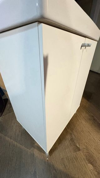 Mueble de baño blanco con lavabo y grifo