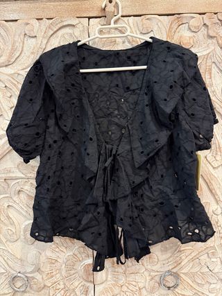 Blusa negra con volantes y lazada