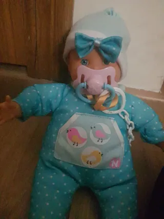 Muñeco bebé con pijama azul y lazo