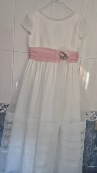 Vestido de comunión blanco con fajín rosa.