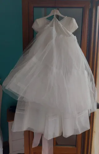 Vestido de comunión blanco con fajín rosa.