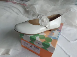 Vestido de comunión blanco con fajín rosa.