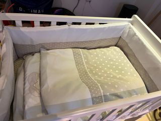 Minicuna de madera con sábanas