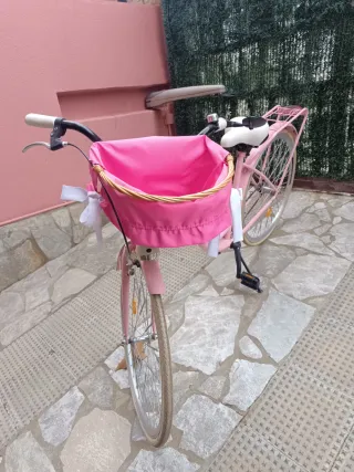 Bicicleta rosa y blanca con cesta