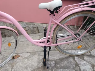 Bicicleta rosa y blanca con cesta
