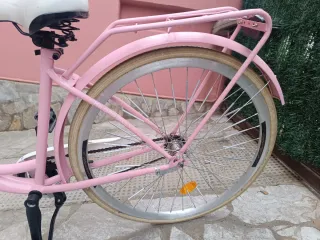 Bicicleta rosa y blanca con cesta