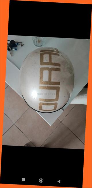 Casco de moto blanco con letras doradas