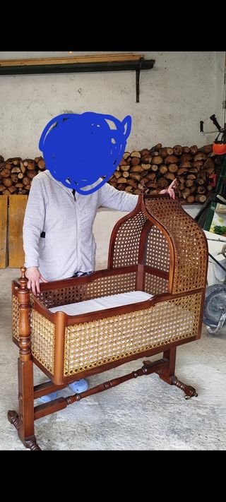 Cuna antigua de madera y mimbre del año 1908.