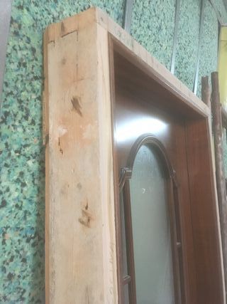 Puerta madera con cristal y manivela.