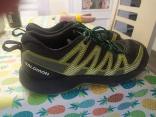 Zapatillas Salomon montaña negras y verdes.
