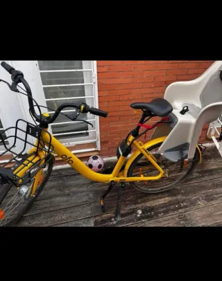 Bicicleta amarilla Ofo con silla para niño