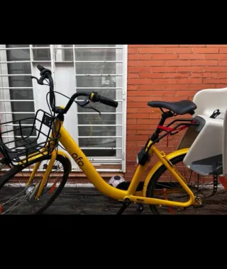Bicicleta amarilla Ofo con silla para niño