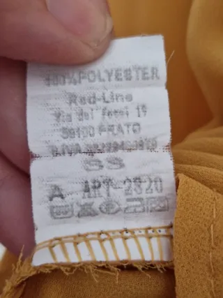 Blusa mostaza con escote de cremallera.