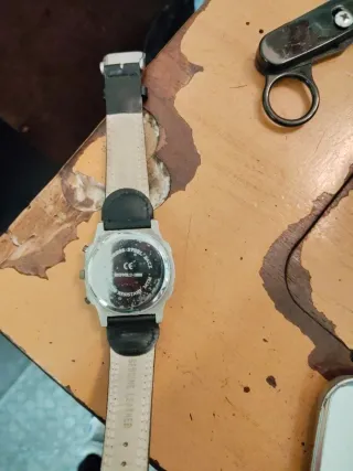Reloj plateado y negro con su caja